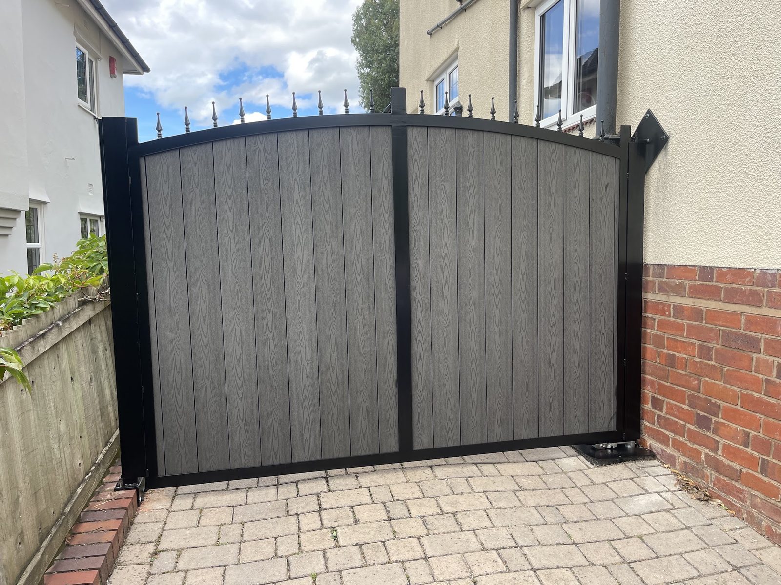 Arched board gates between brick piers