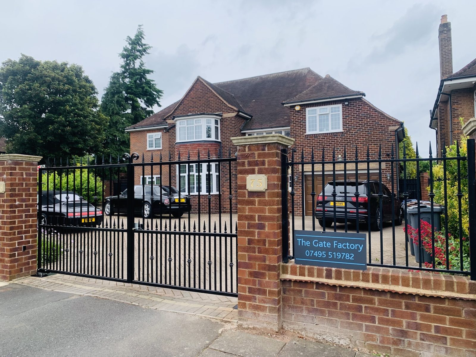 Black railings and gates along a brick front wall